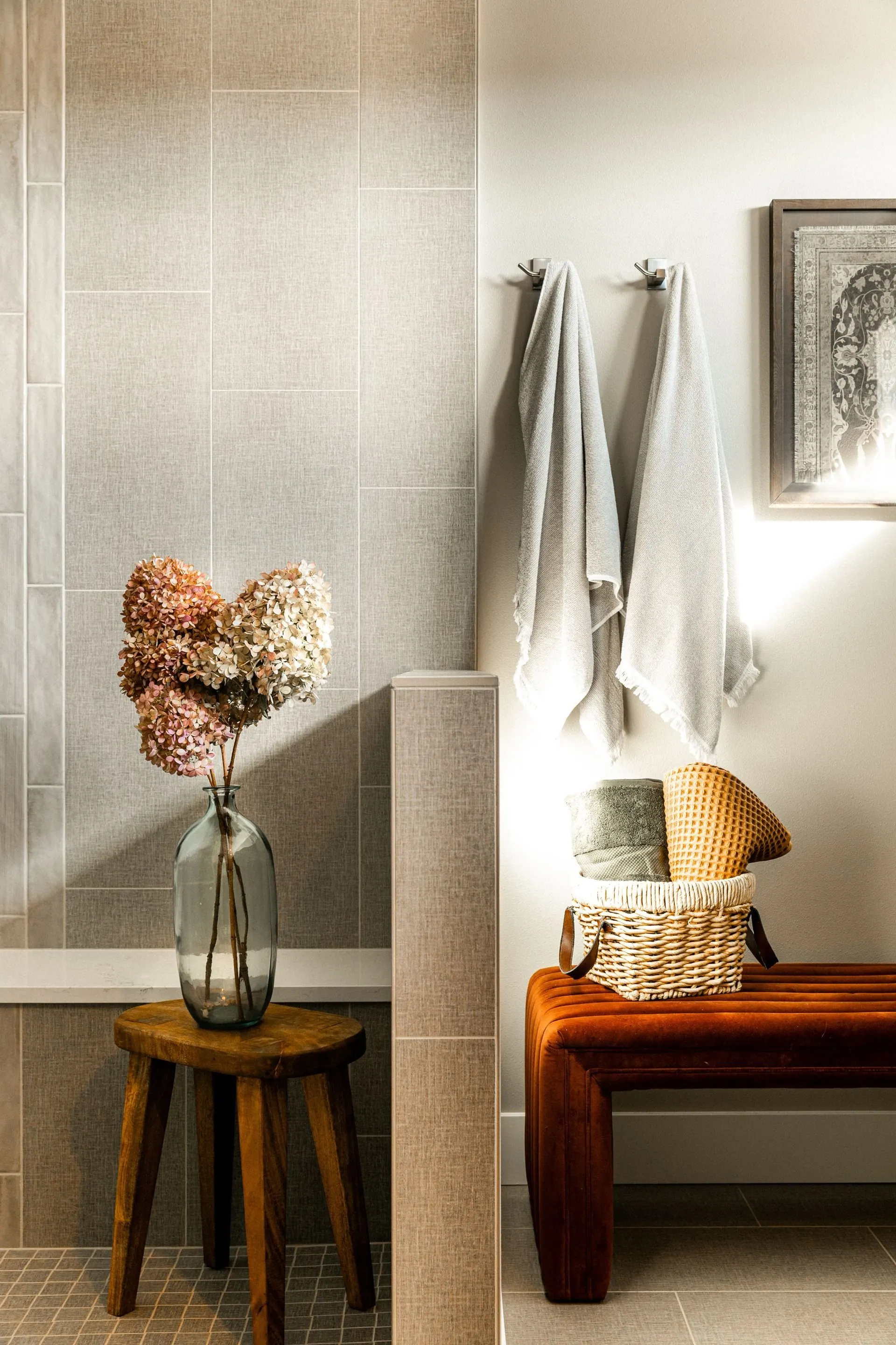 Entry console styled with a table lamp, sculptural florals, and layered objects