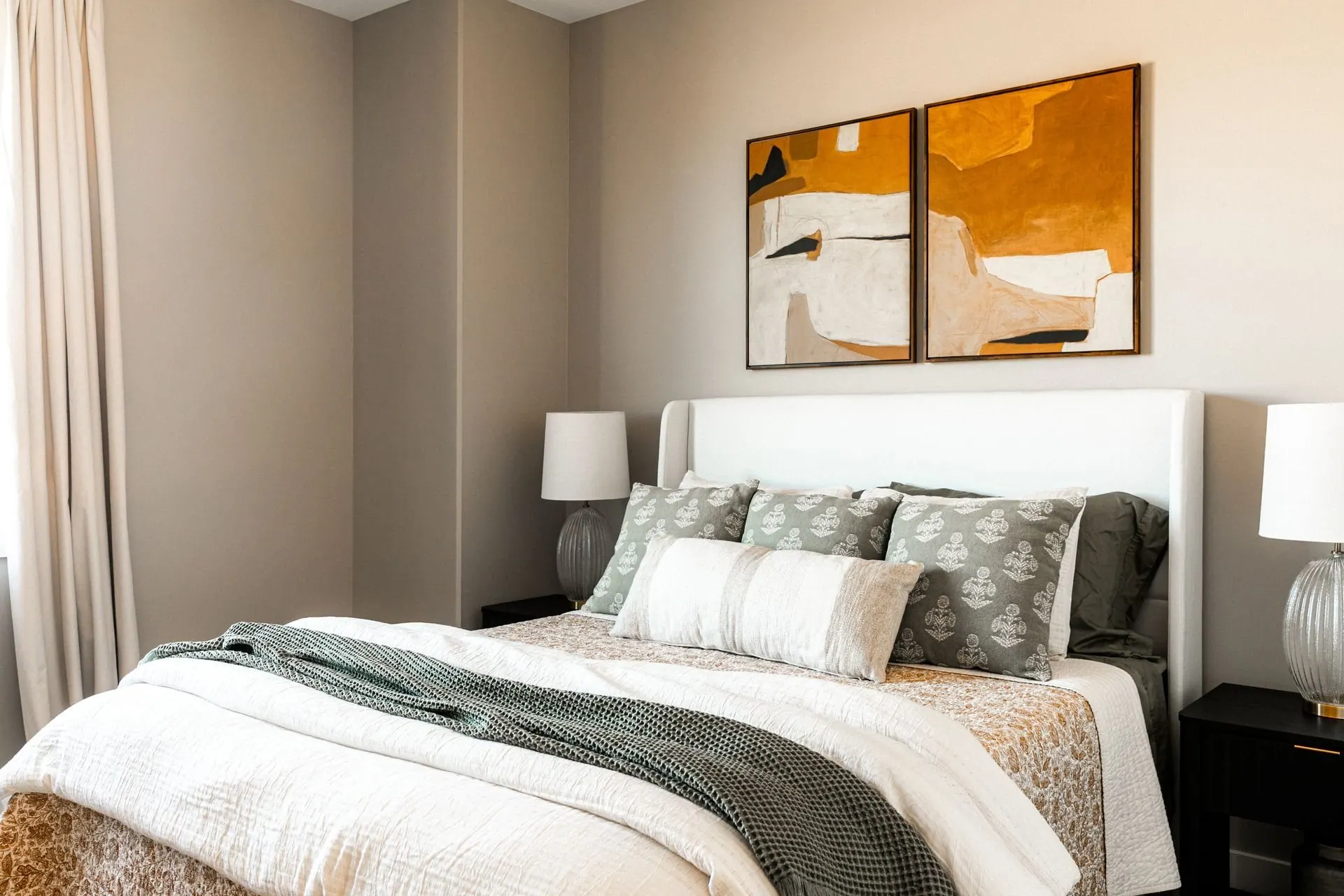 Serene primary bedroom with an upholstered bed and layered neutral styling