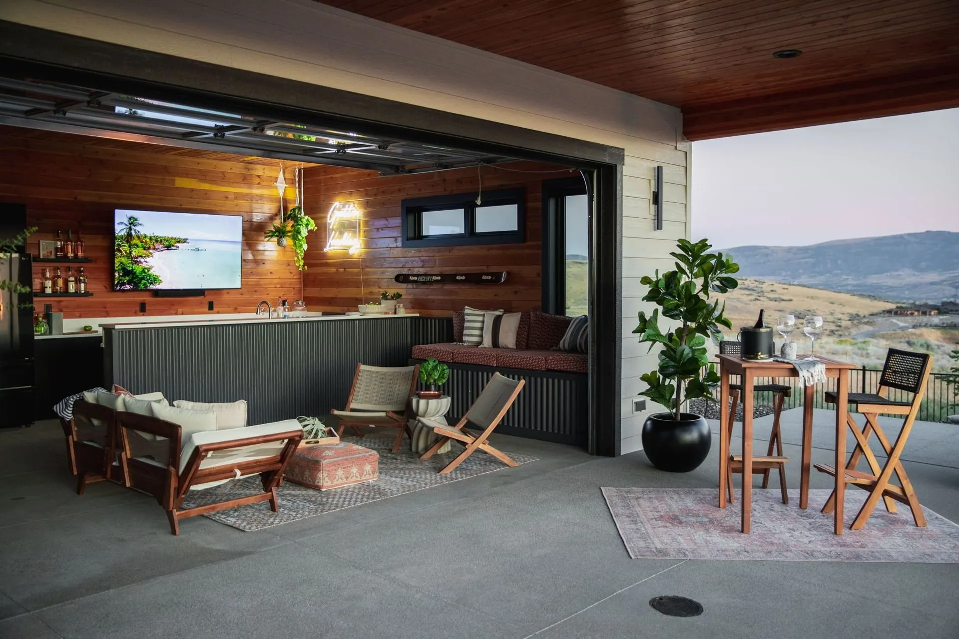 Covered patio opened to the main living space by a folding glass wall, with a shared bar counter and valley views