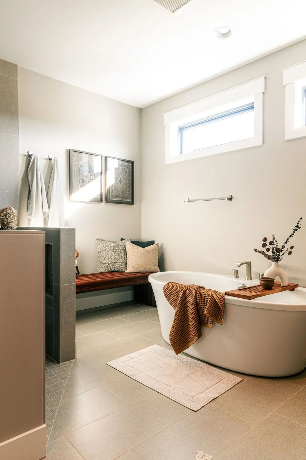 Renovated bathroom with a freestanding soaking tub set beneath a window with natural light
