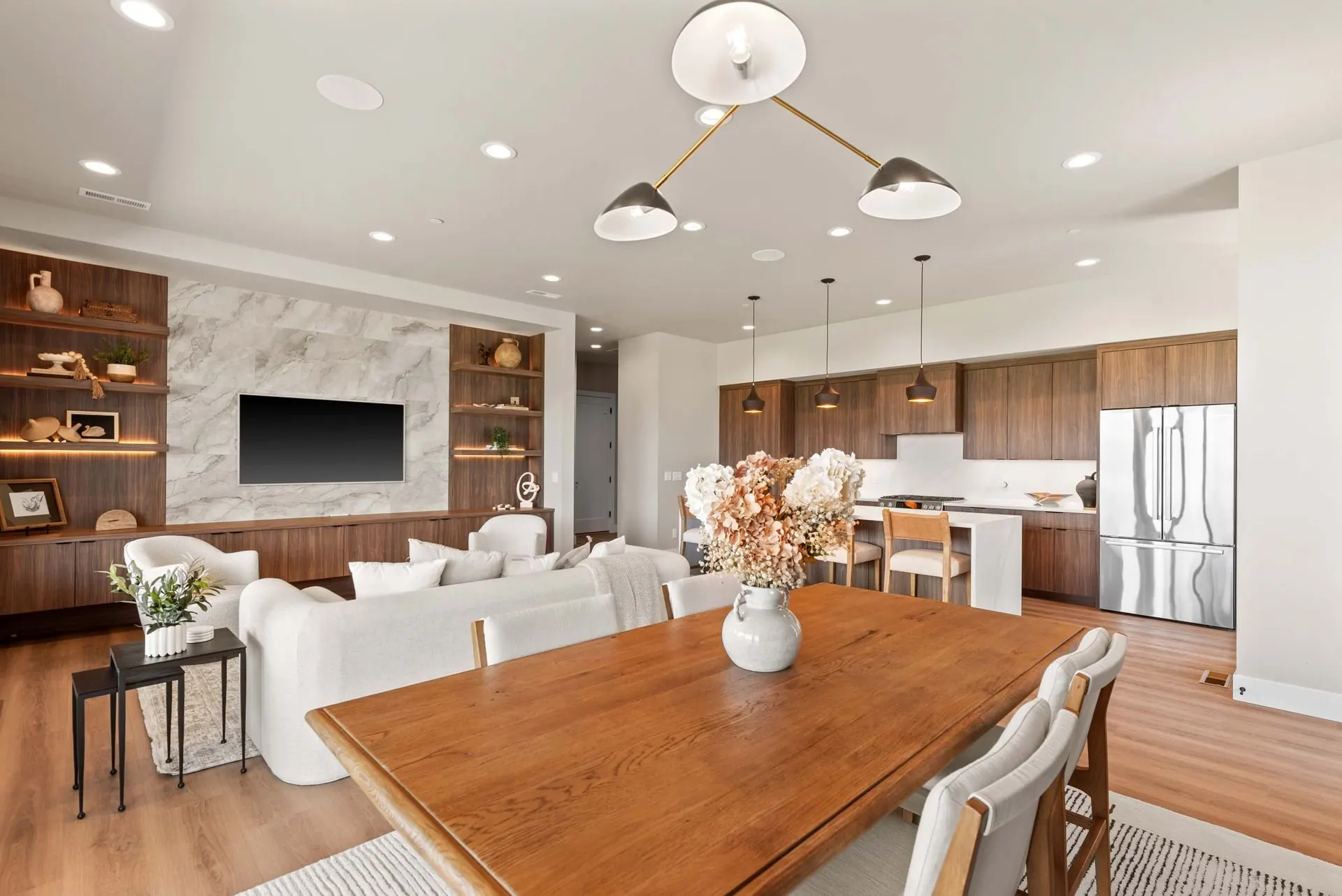 Open-concept living, dining and kitchen with cohesive finishes and layered furnishings